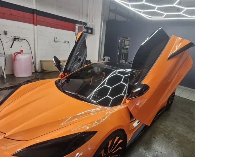 Orange sports car with butterfly doors in a modern car wash setting, showcasing expert detailing and attention to quality service at Mr. Shine in Pickering.