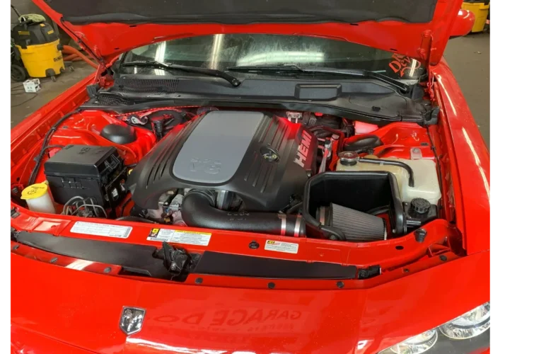 Red sports car engine bay showcasing a powerful HEMI engine, emphasizing expert car care and attention to detail at Mr. Shine hand car wash in Pickering.